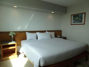 a bedroom with a large bed with white sheets at Hotel Amberes in Querétaro