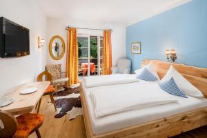 a bedroom with two beds and a table and a desk at Hotel Oremushof in Velden am Wörthersee