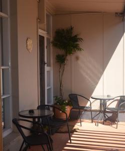 a patio with tables and chairs and a potted plant at Clifton Motel in Albury