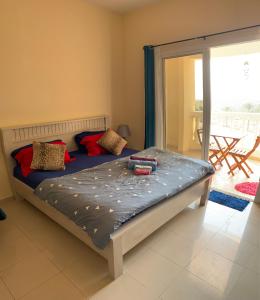 a large bed in a room with a sliding glass door at Wait N Sea !! Sea View Studio Ras Al Khaimah in Ras al Khaimah