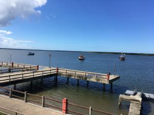 a dock with boats in a large body of water at Residencial Beira Mar Cananéia in Cananéia