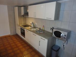 una pequeña cocina con fregadero y microondas en Haus Wangen 