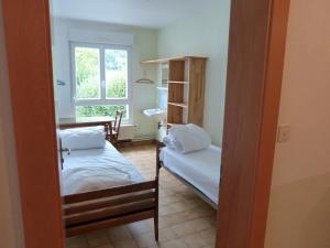 Ban-sur-Meurthe-ClefcyにあるLa Saucéeのベッド2台、テーブル、窓が備わる客室です。