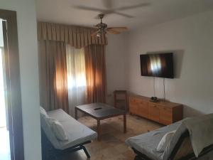 sala de estar con cama, mesa y TV en CHalet aeropuerto Sevilla en Sevilla