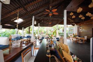 un restaurant avec une table, des chaises et un plafond dans l'établissement The Beach Natural Resort Koh Kood, à Ko Kood
