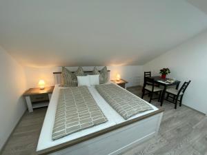 a large bed in a room with a table and chairs at Ossiach Apartment 2 in Heiligen Gestade