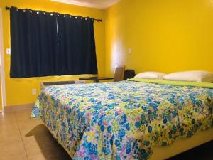 um quarto com uma cama num quarto amarelo com uma janela em Commodore Motel em Oakland