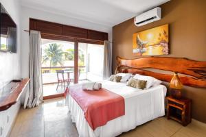 a bedroom with two beds and a balcony at Vila Coqueiros Boutique Hotel in Cumbuco