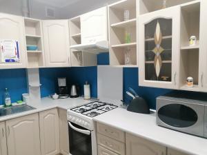 a kitchen with white cabinets and a stove top oven at Apartamenty Copernicus - zameldowanie całodobowe, parking in Toruń