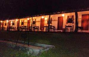 un edificio con mesas y sillas por la noche en Fazenda da Roseta - Turismo Rural e Passeios a Cavalo -, en Baependi