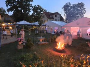 a group of people standing around a fire in a yard at Hotel Alttolkewitzer Hof in Dresden