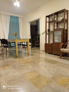 a living room with a table and chairs and a dining room at Stamatis Big Apartment in Spata