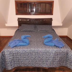 Una cama con dos toallas azules encima. en CABAÑAS VILLA CLUB 2 cerca de aeropuerto El Palomar en Hurlingham