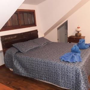 Un dormitorio con una cama con un osito de peluche azul. en CABAÑAS VILLA CLUB 2 cerca de aeropuerto El Palomar en Hurlingham