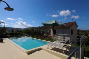 a swimming pool with a chair and an umbrella at Villa Santulli in Laureana Cilento