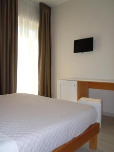 una camera con letto, scrivania e TV di Hotel La Campagnola a Rotondi