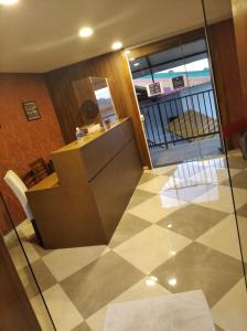 a lobby with a counter and chairs on a tiled floor at Golden Forest Pousada in Campos do Jordão