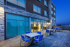 un patio avec des tables et des chaises en face d'un bâtiment dans l'établissement Holiday Inn Express & Suites Purcell, an IHG Hotel, à Purcell