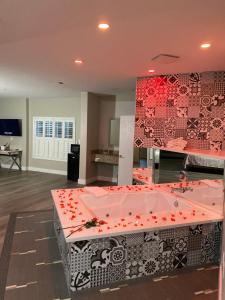 una grande vasca da bagno rosa con fiori rossi di Mid City Inn & Suites Pico Rivera a Pico Rivera