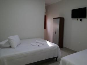 1 Schlafzimmer mit 2 Betten und einem Flachbild-TV in der Unterkunft Pousada Canoa de Tolda II in Piranhas