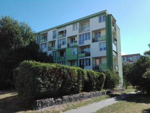 un immeuble d'appartements avec des buissons devant lui dans l'établissement Mieszkanie Bez Barier, à Szczecin