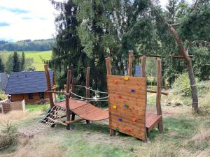 plac zabaw z dwoma drewnianymi huśtawkami na dziedzińcu w obiekcie Roubenky Bublava w mieście Bublava