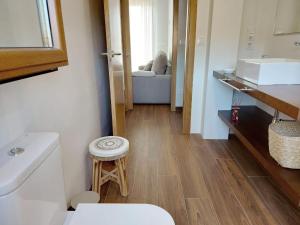 een badkamer met een toilet, een wastafel en een kruk bij Mirador Ría de Aldán Apartamentos in Aldán