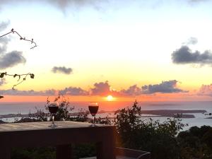 two glasses of wine sitting on a table with the sunset at The Paradise Peak in Saint Martin