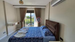 a bedroom with a bed with a blue comforter and a window at Dalyan Villa Carmen-1 in Dalyan +42 photos