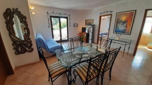 a dining room with a glass table and chairs at Villa Linet Garden in Funtana