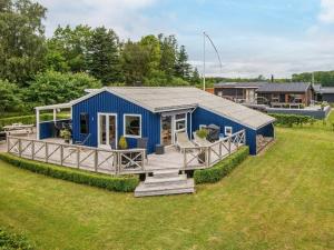 ein kleines blaues Haus auf einem Grasfeld in der Unterkunft Holiday home Juelsminde LXVIII in Sønderby