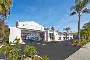 een rij witte gebouwen met palmbomen bij Motel 6-Redlands, CA in Redlands