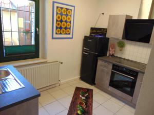 桑格豪森的住宿－FerienAppartement NO.18，厨房配有黑色冰箱和炉灶。