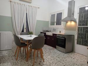 eine Küche mit Tisch, Stühlen und Herd in der Unterkunft Danesi House in Leonidi