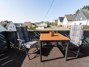a patio table and two chairs on a balcony at Apartment in Westerwald with private balcony 