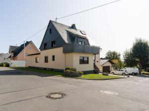 a house with a black roof on a street at Apartment in Westerwald with private balcony 