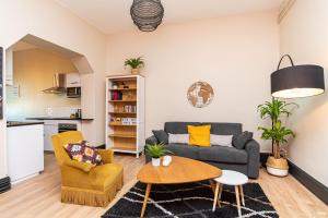 sala de estar con sofá y mesa en Appartements Scaliger Jardin Wifi Proche Gare, en Agen