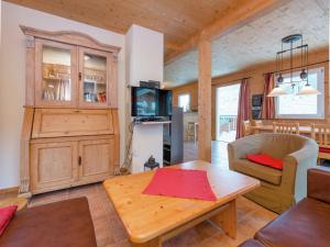 a living room with a table and a tv at Spacious Chalet in Annaberg-Lungötz with sauna in Annaberg im Lammertal