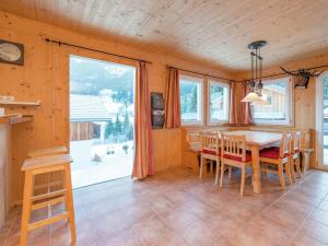 a dining room with a table and a large window at Spacious Chalet in Annaberg-Lungötz with sauna in Annaberg im Lammertal