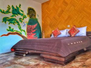 ein Schlafzimmer mit einem Bett mit einem Pfau an der Wand in der Unterkunft Hotel Posada Jarritos in Cuetzalán del Progreso
