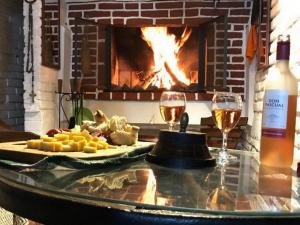 a table with two glasses of wine and a fireplace at Chalé Alto in Soriano