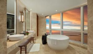 ein Badezimmer mit zwei Waschbecken und einem großen Fenster in der Unterkunft InterContinental Haikou Seaview, an IHG Hotel in Haikou