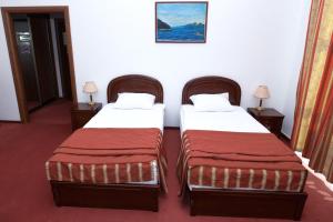 a hotel room with two beds and two lamps at Siberia Hotel in Ulan-Ude