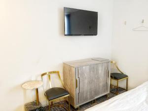 a bedroom with two chairs and a tv on the wall at The Barn Tokyo in Tokyo