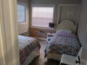 a bedroom with two beds and a window at Tropical Sky Ranch Motel in Clearwater Beach