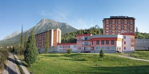 um grupo de edifícios em frente a uma montanha em Grand Hotel BELLEVUE em Starý Smokovec