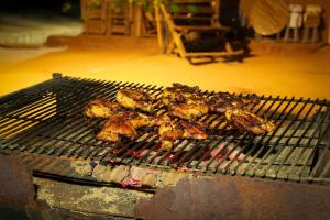 a bunch of chicken cooking on a grill at Yala Dream Park in Yala