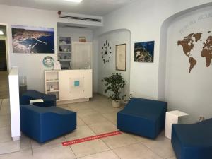a waiting room with blue chairs and a world map on the wall at Bike&Boat Argentario Hotel in Porto Santo Stefano