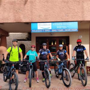 a group of people on bikes in front of a hotel at Bike&Boat Argentario Hotel in Porto Santo Stefano