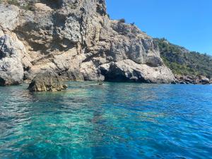 a large body of water next to a rocky cliff at Bike&Boat Argentario Hotel in Porto Santo Stefano